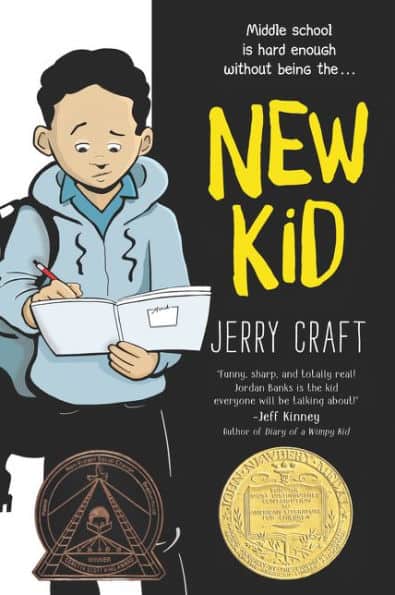 Paperback book cover showing a standing African American middle school boy wearing a black backbook and a light blue hoodie over a darker blue collared shirt, holding an open notebook in his left hand that he is writing in with his right hand.  Text to the right of the kid reads 'Middle school is hard enough without being the... / NEW KID / JERRY CRAFT / 'Funny, sharp, and totally real! / Jordan Banks is the kid / everyone will be talking about!' / - Jeff Kinney / Author of Diary of a Wimpy Kid' The Newbery Medal is displayed on the lower right, and the Coretta Scott King award logo is displayed on the lower left.