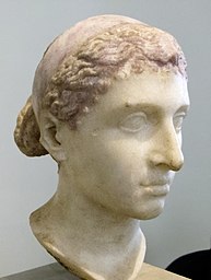 Marble bust of Cleopatra VII of Egypt from ca. 40-30 BC. An ancient Roman bust of Ptolemaic ruler Cleopatra VII of Egypt wearing a royal diadem band over her hair; dated to the mid-1st century BC (i.e. around the time of her visit to Rome), it was discovered in a villa along the Via Appia. It is now located in the Altes Museum, Berlin, in the Antikensammlung Berlin collection.
العربية:  تمثال لرأس الملكة كليوبترا معروض في متحف ألتيس في برلين
Sources:

Raia, Ann R.; Sebesta, Judith Lynn. (September 2017). 
