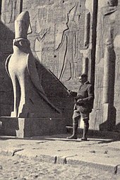 English Egyptologist Arthur Weigall beside a statue of Horus at the temple of Edfu, Egypt, 1913 or shortly before. Photo by N. Macnaghten.