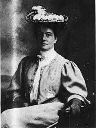 A white woman with her hair in an updo, wearing glasses and a soft jacket