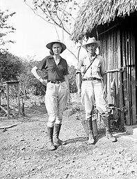 Marion Stirling and Matthew Stirling, dressed in field clothes, outside a building in Boca San Miguel, Veracruz, Mexico, on 15 April 1939. Photograph taken by Alexander Wetmore during a visit to the Stirlings' archaeological expedition to Mexico and held in the Smithsonian Institution Archives.