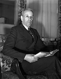 Former diplomat Pierrepont B. Noyes sits upright with an open book positioned in his lap. He talks about, fuel, civilians, the government, the French and German and that the prospect of war is unlikely. Photograph appears with the article, 
